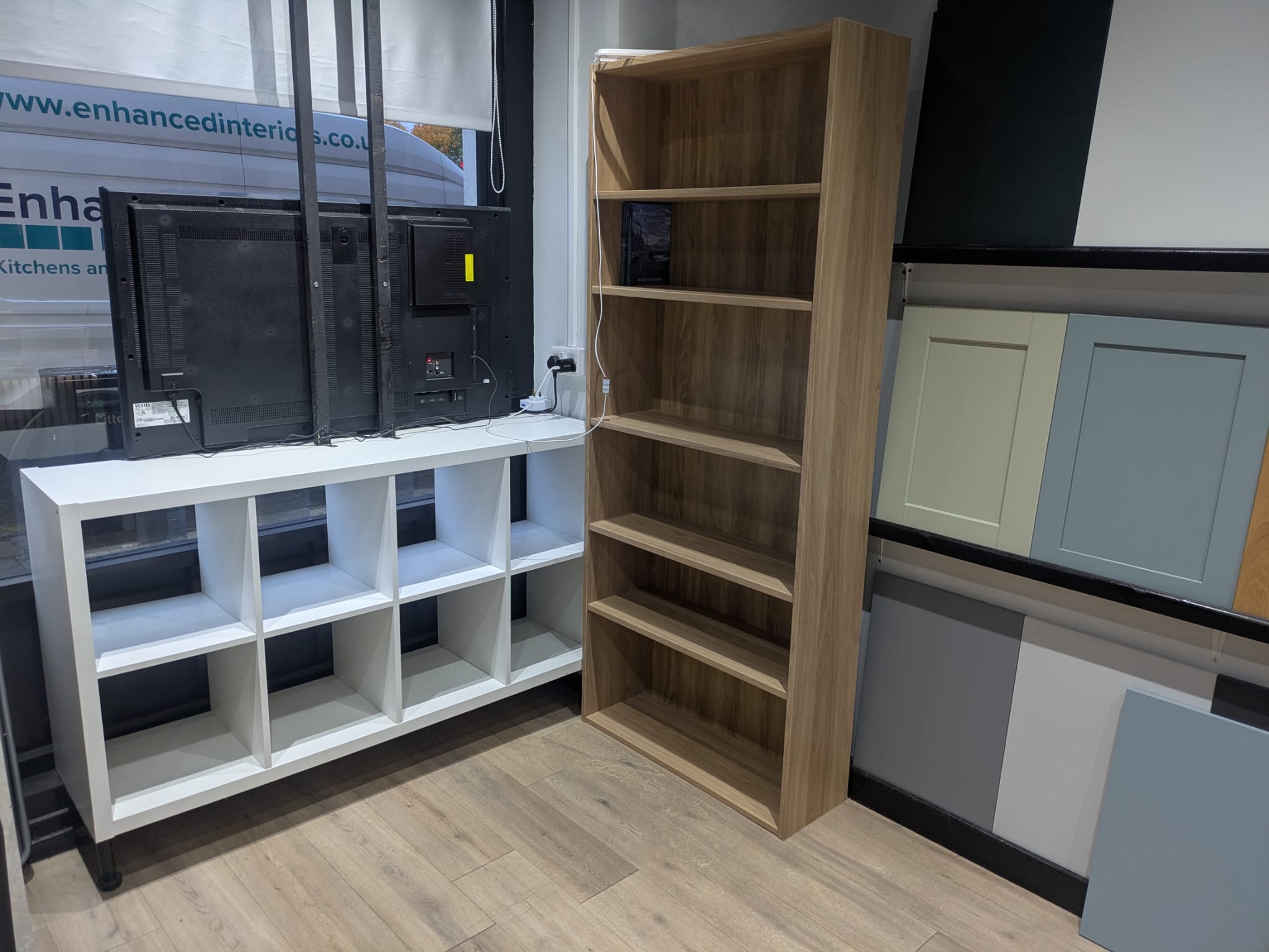 The Little Shelf's white cube shelves and tall oak bookcase inside the showroom